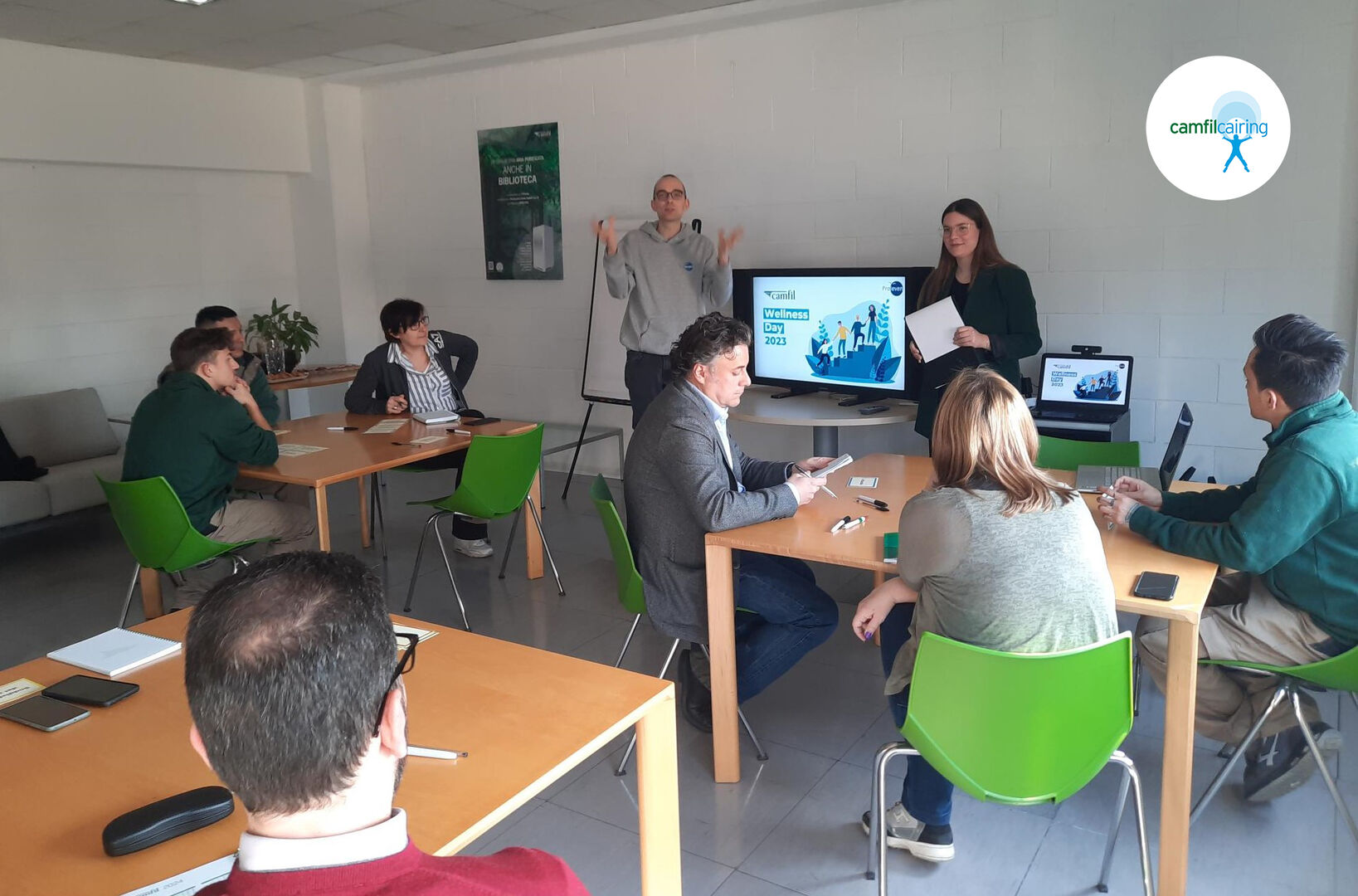 Incontro formativo in una sala di Camfil Italia dedicato alle relazioni umane, alla socialità e all’empatia, con colleghi seduti ai tavoli mentre due facilitatori presentano slide e attività a cura di Proleven.