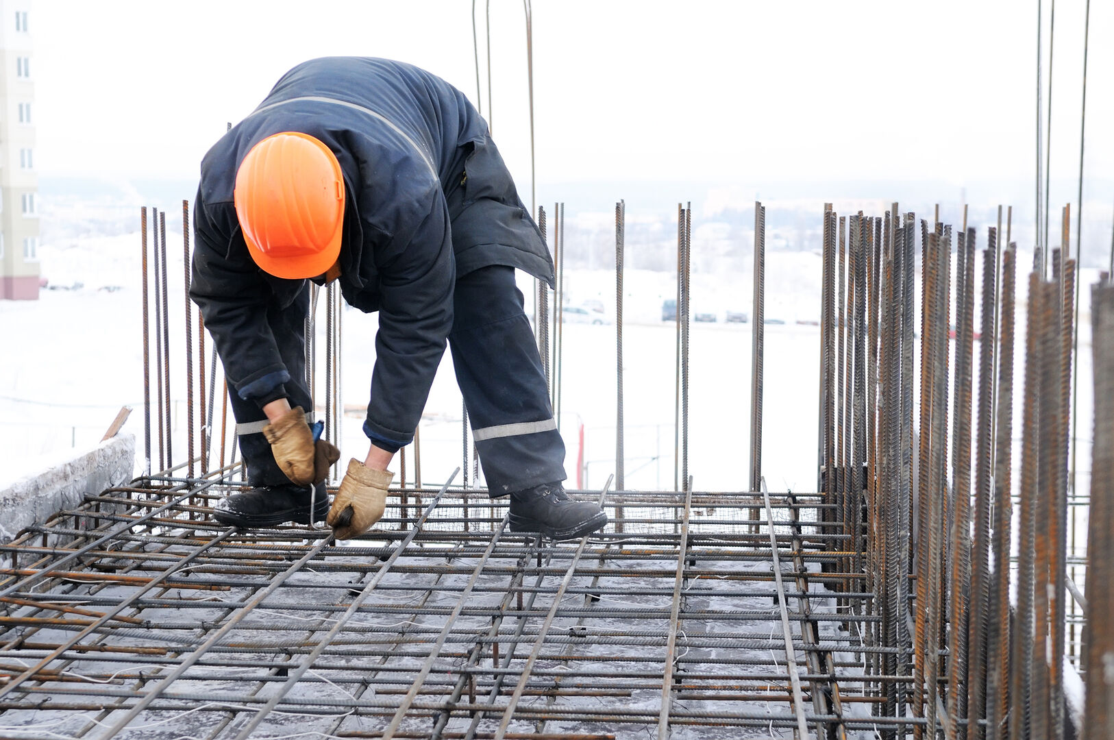 worker in workwear making reinforcement metal framework for concrete pouring