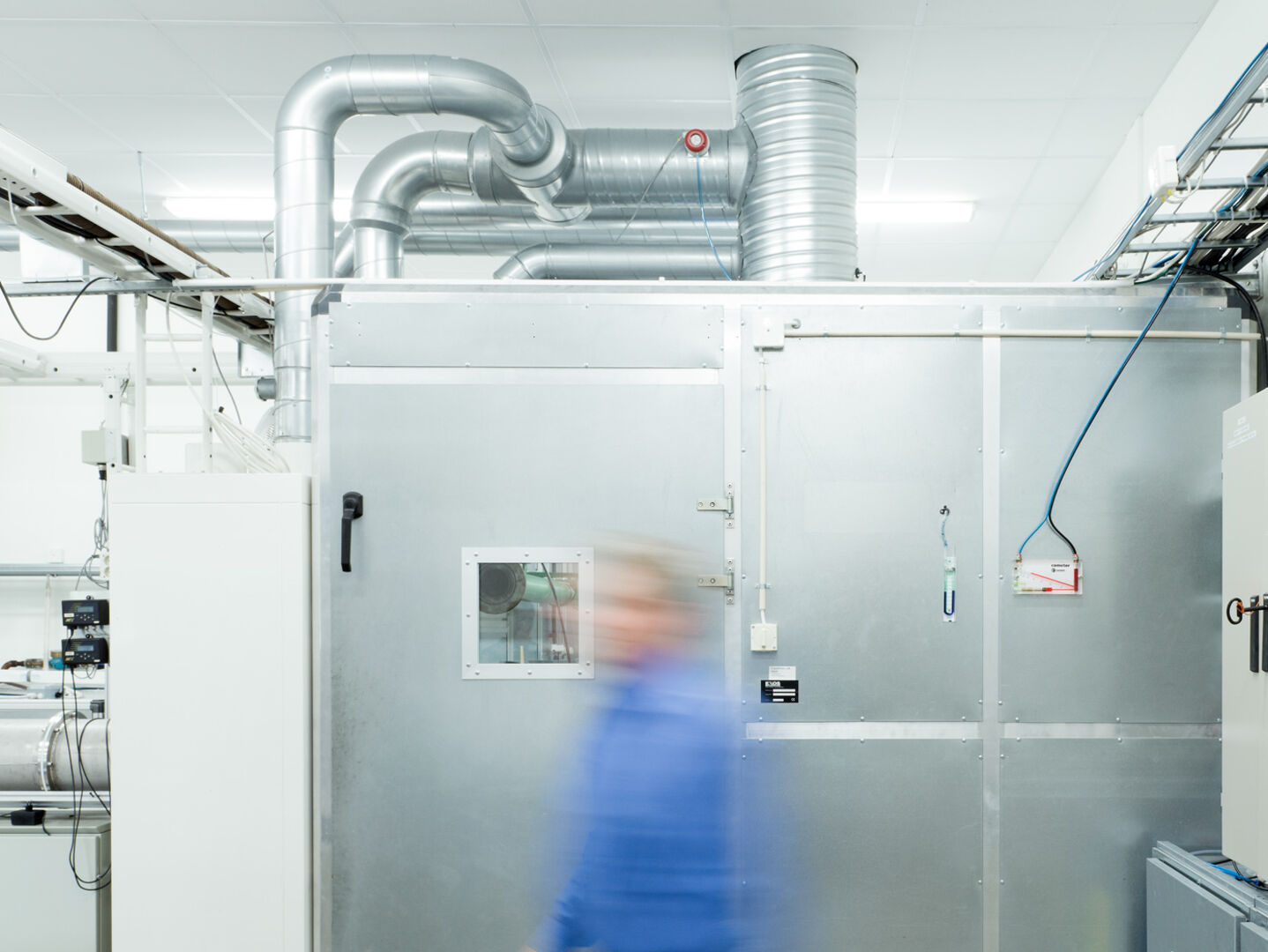 Person geht an einer Lüftungsanlage vorbei