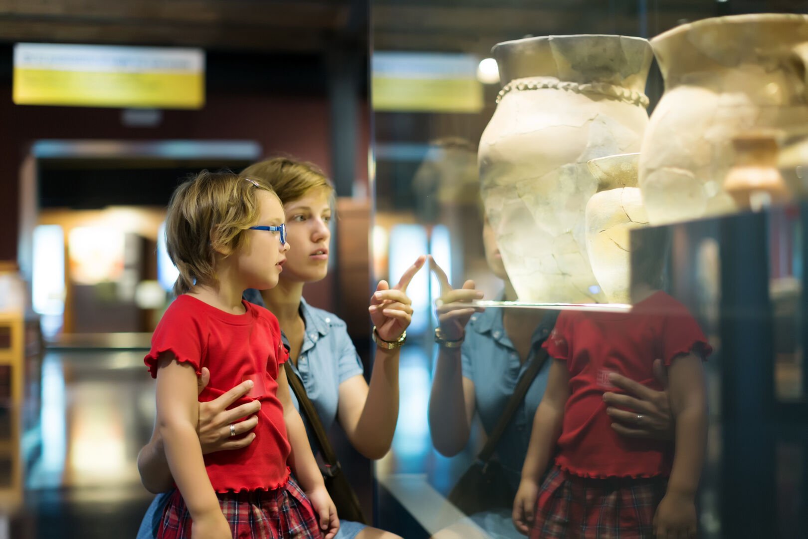 mother and child looking old amphores in museum