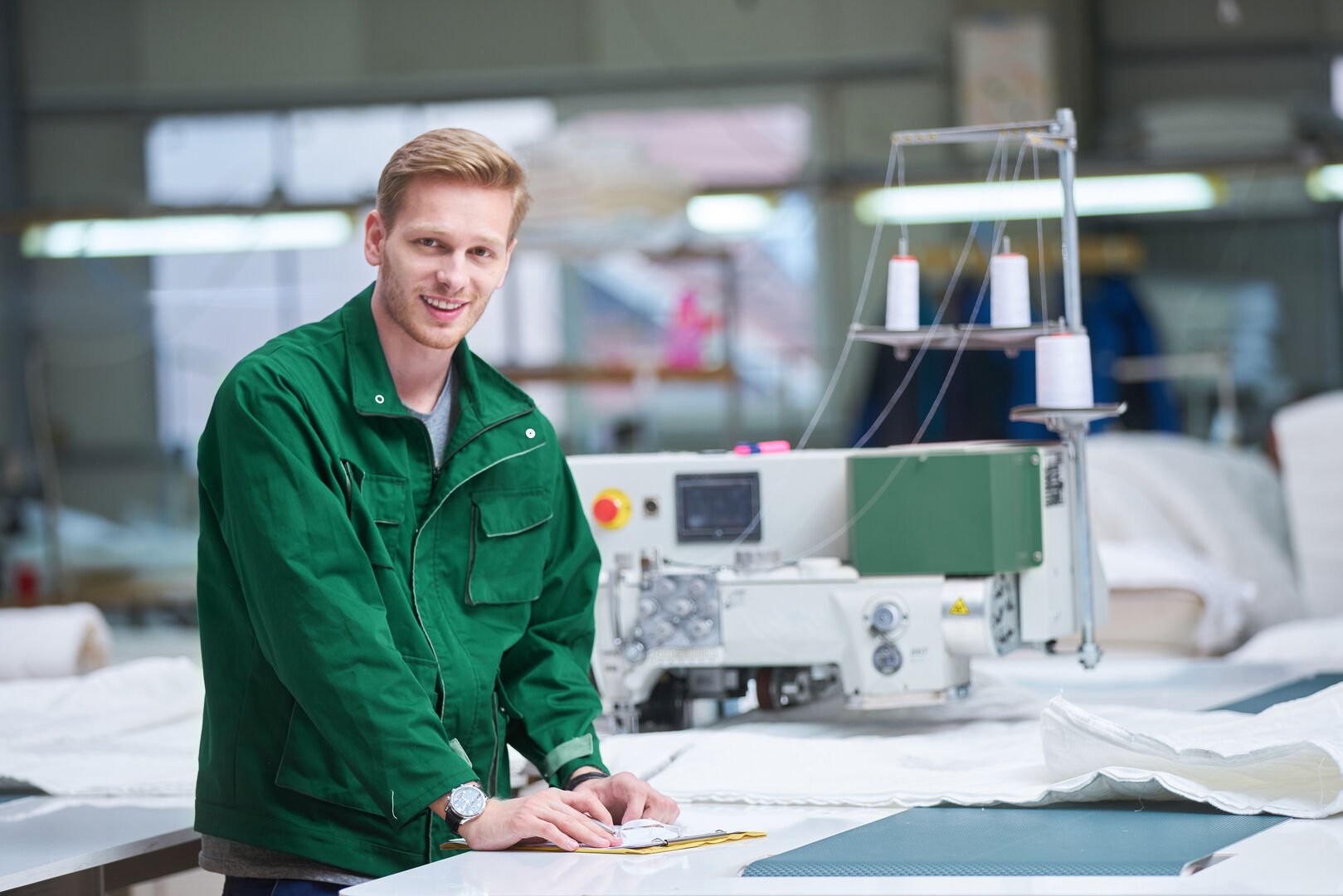 worker in protective clothing in factory using machine Free to use royaltyfree