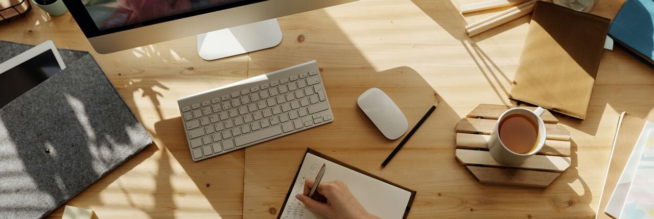 Top-down view of a person attending a training session and taking notes.