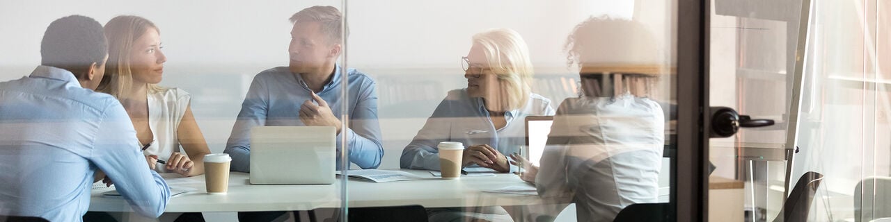 People sitting and talking in a conference room.